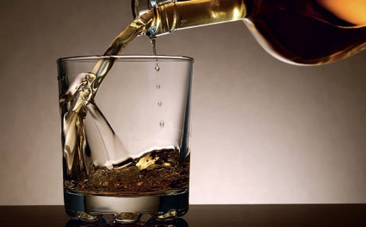 Točenje alkohola iz boce u čašu
